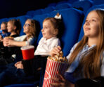 selective focus smiling little girl holding popcorn bucket sitting with laughing friends comfortable chairs cinema children watching cartoon movie enjoying time 1 Семь виртуальных концертных зала открыли в Мордовии