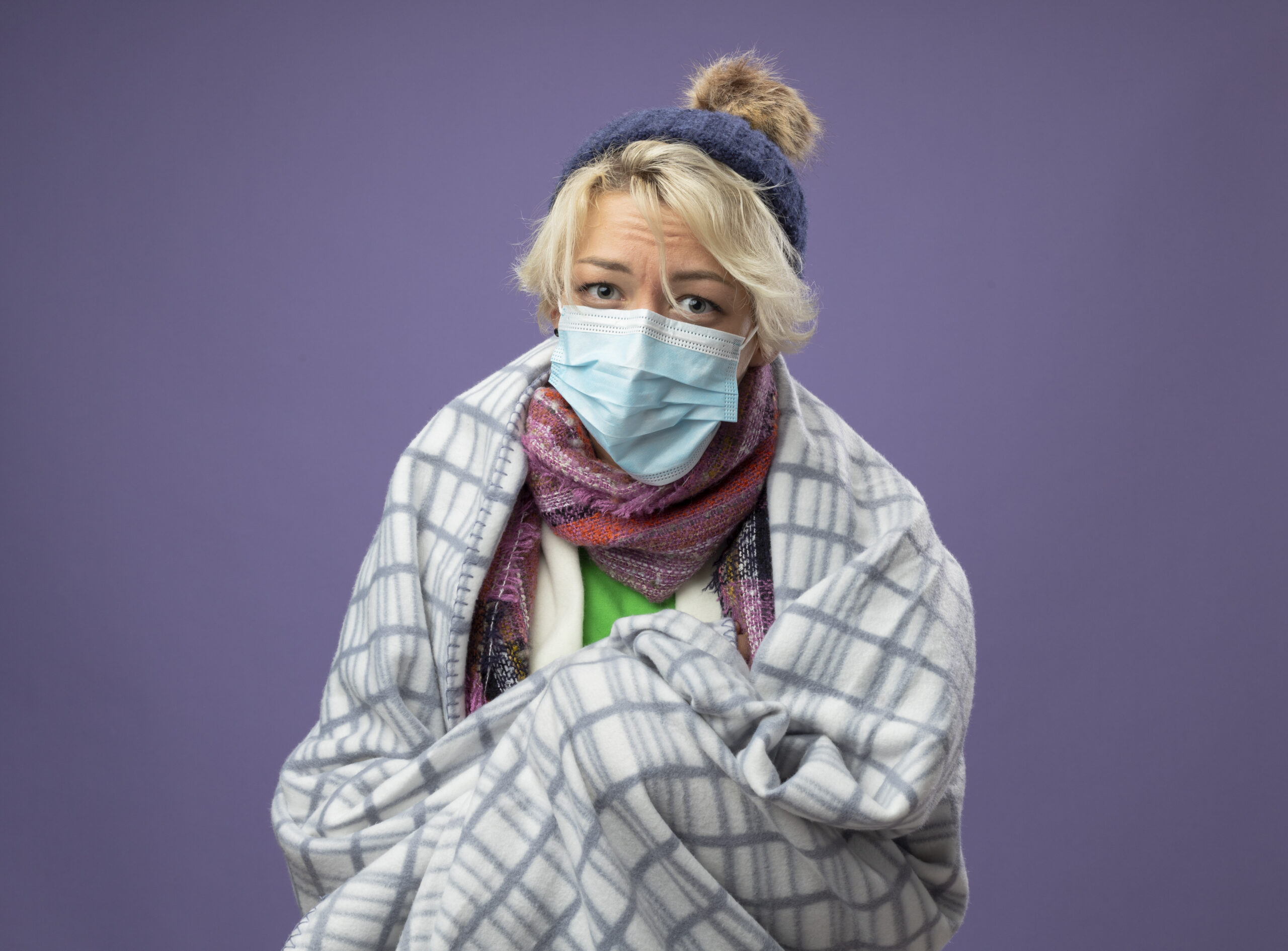 sick unhealthy woman with short hair warm hat scarf wearing protective facial maskwrapped blanket feeling unwell looking camera unhappyover purple background scaled В Мордовии наблюдается рост заболеваемости ОРВИ